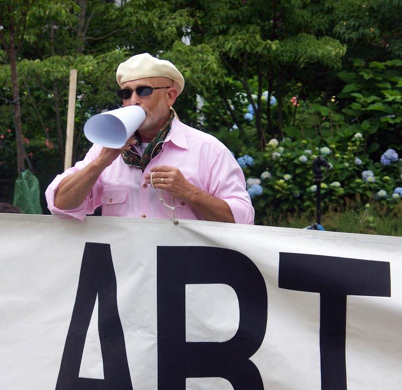 Gary Taylor directs spectators as he marches with members of the Marion Art Center. BY MATTHEW BERNAT